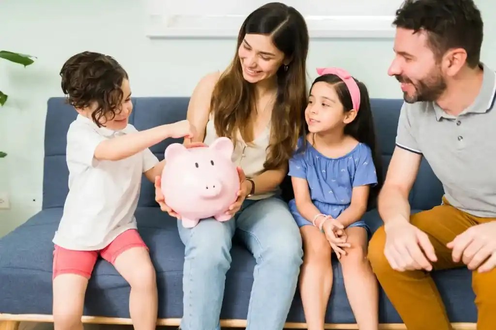 Padres y sus dos hijos ahorrando en una alcancia