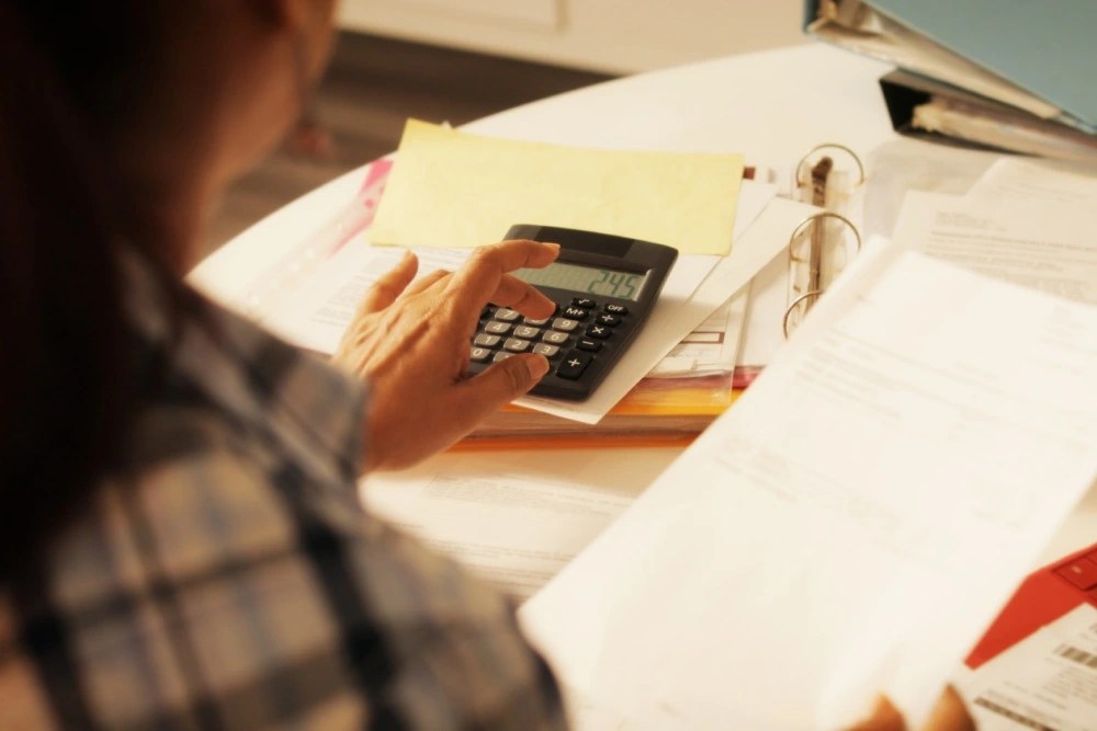 Mujer calculando los gastos de los servicios del hogar.