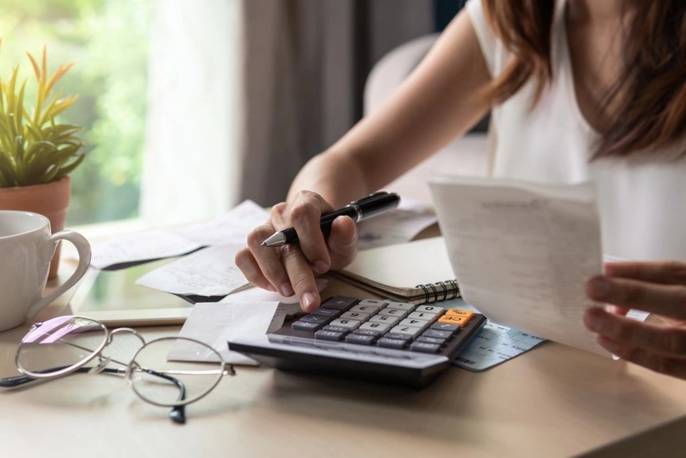 Una mujer calcula sus gastos para evaluar su situación financiera