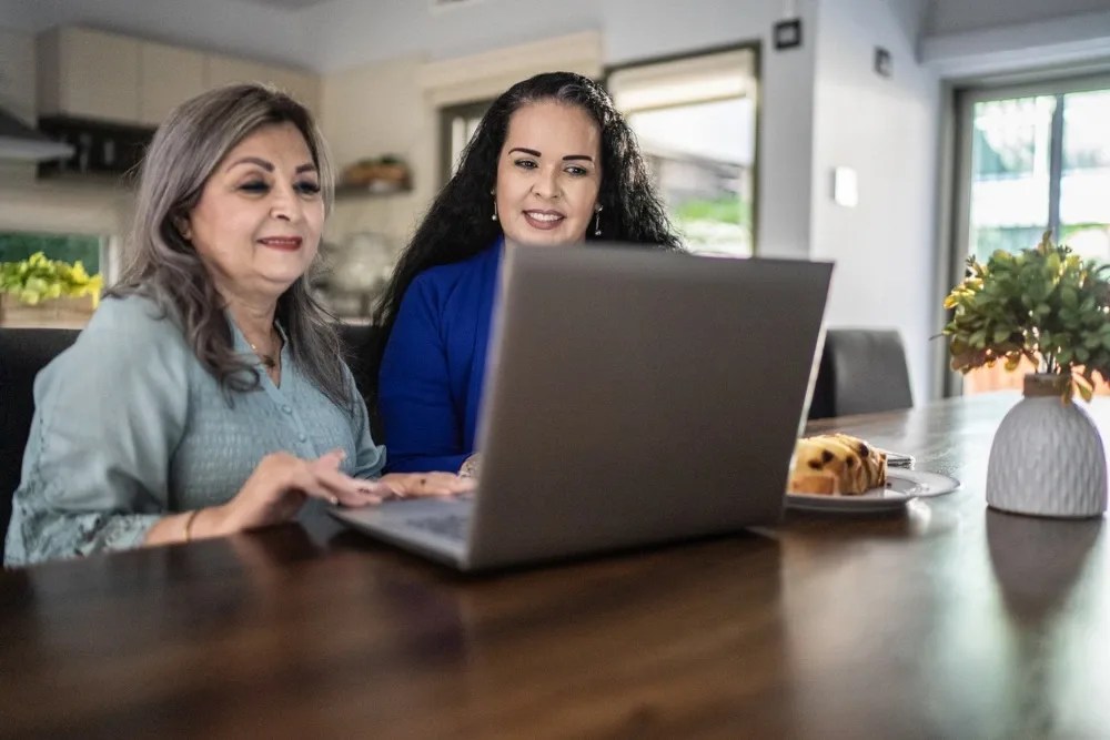Madre e hija aprendiendo en internet cómo invertir
