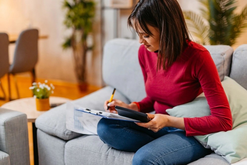 Mujer sacando cuentas para crear su fondo de emergencia