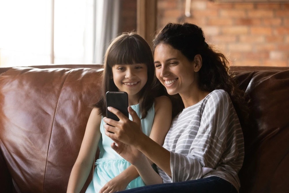 Madre e hija revisando la cuenta AFORE para niños.