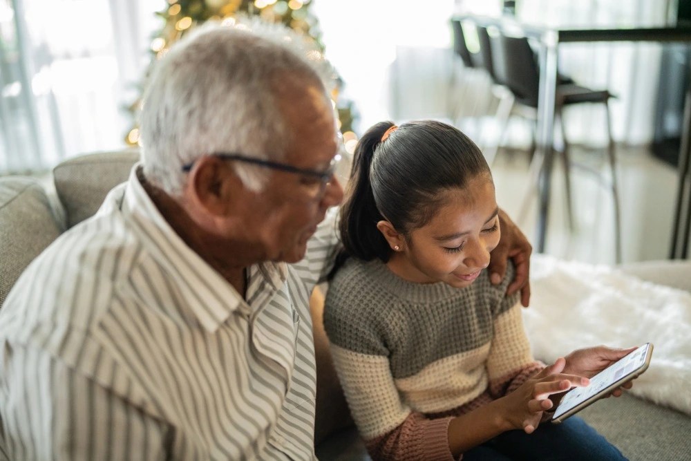 Abuelo y nieta revisando cuentas de ahorro para niños.