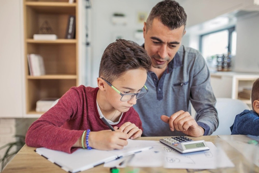 Padre enseñándole a su hijo sobre el valor del dinero y cómo ahorrar.