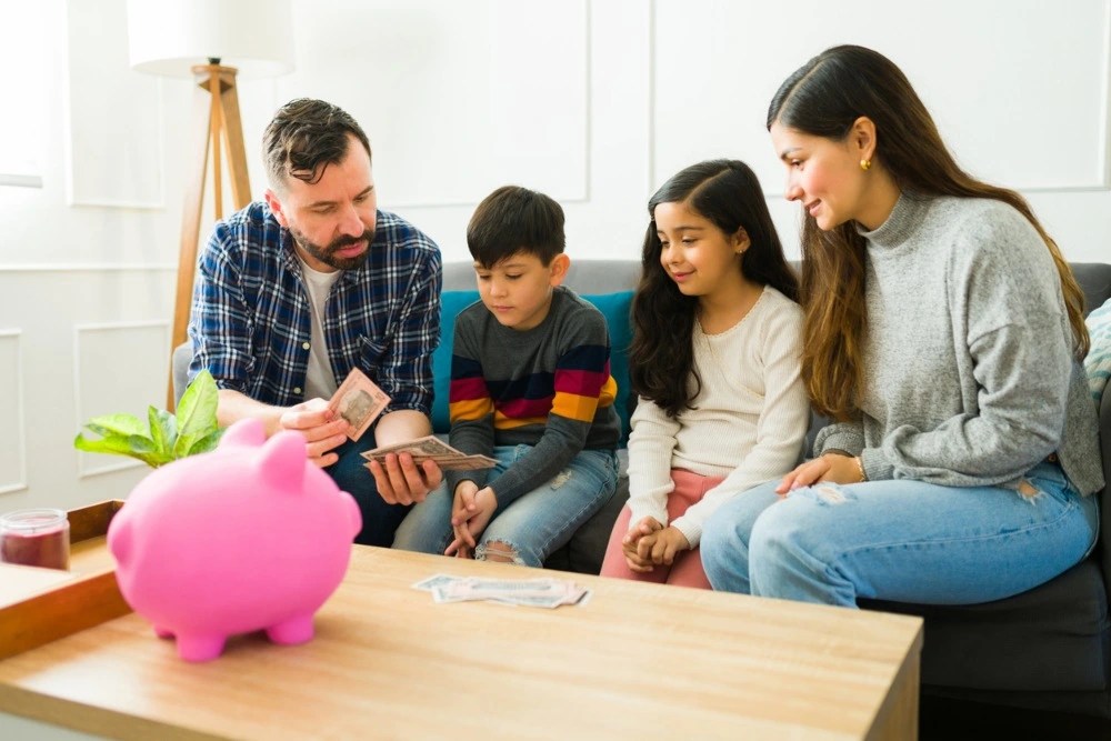 Familia educando a sus hijos sobre el ahorro de dinero.