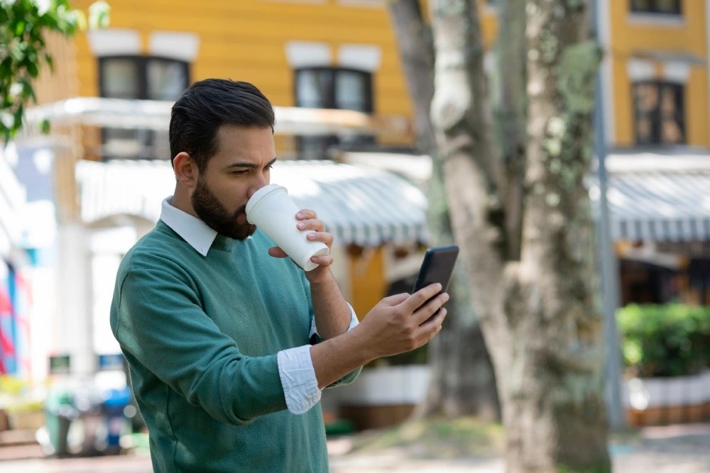 Hombre viendo sus gastos hormiga en el teléfono