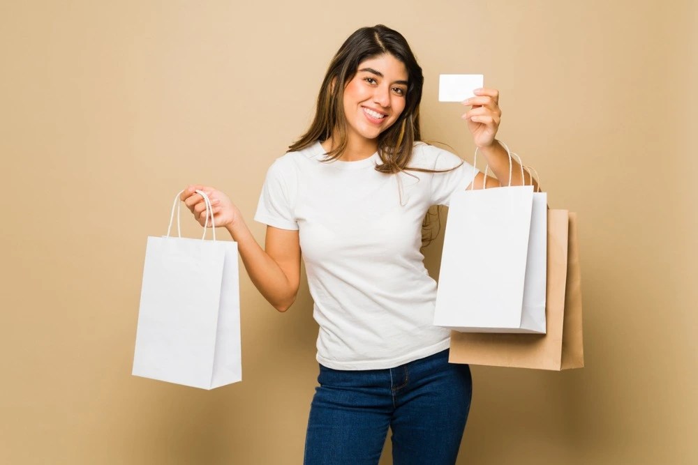 Mujer con bolsas de compras tras usar su monedero electrónico.