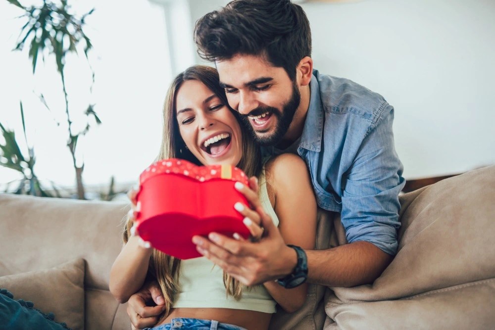 Pareja comparte regalos para San Valentín.