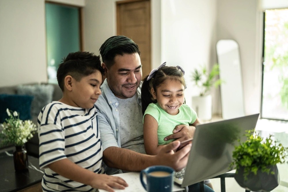 Padre acompañado de sus hijos viendo los tipos de seguros de salud para la familia