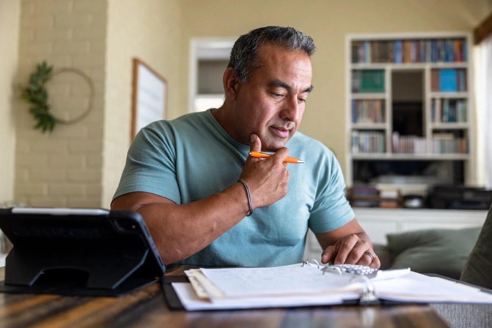 Hombre pensando cómo crear una tabla para ahorrar dinero.