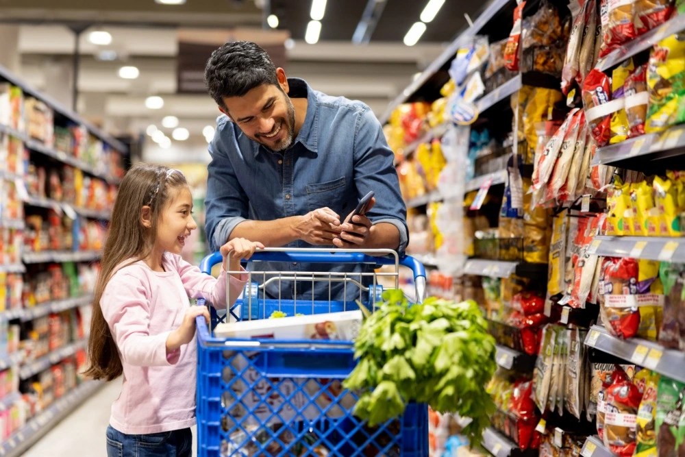 Padre e hija comprando en el supermercado 