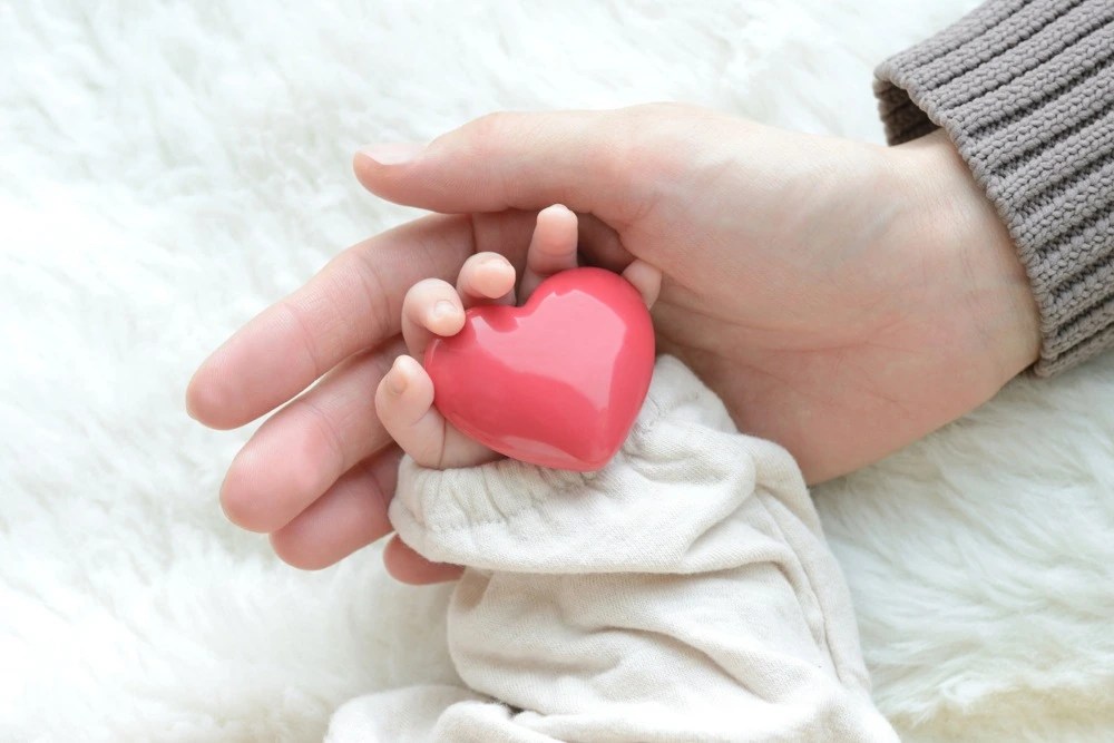 Manos de madre sosteniendo la mano de su bebé