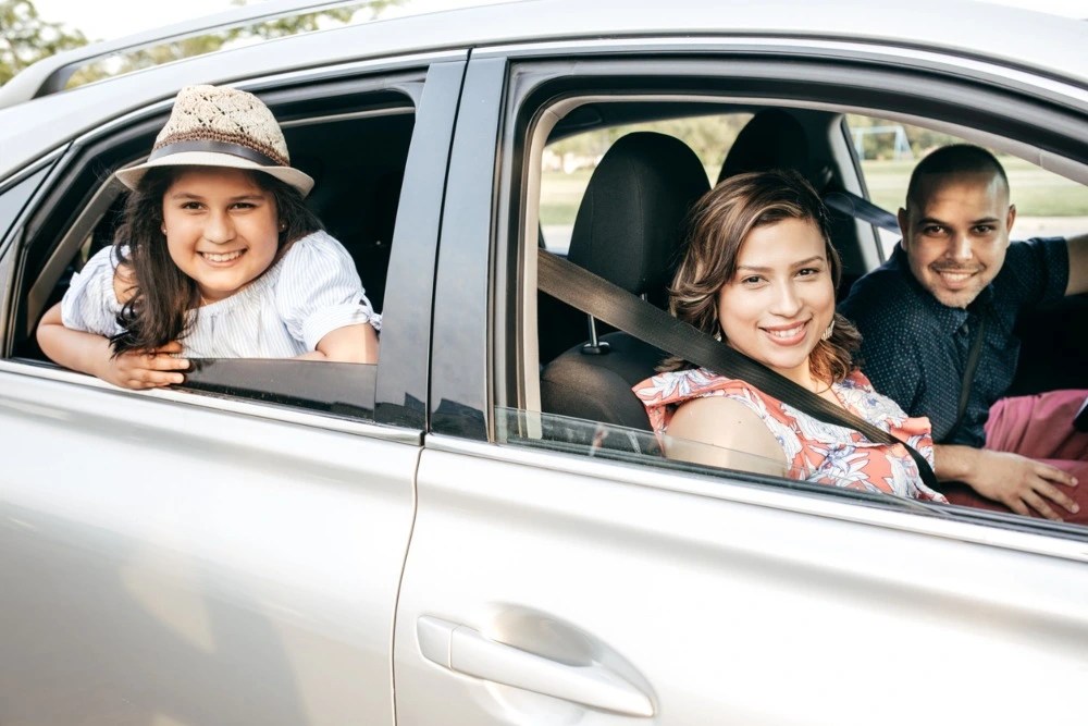 Presupuesto familiar: familia en auto partiendo sus vacaciones.