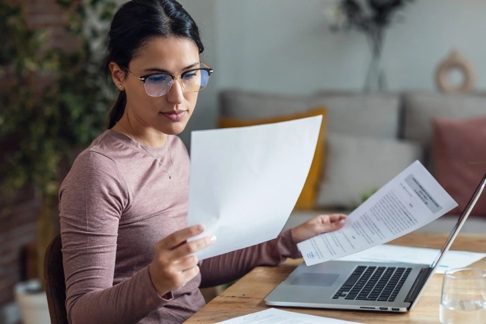 Mujer con documento en mano comparando UMA vs salario mínimo.