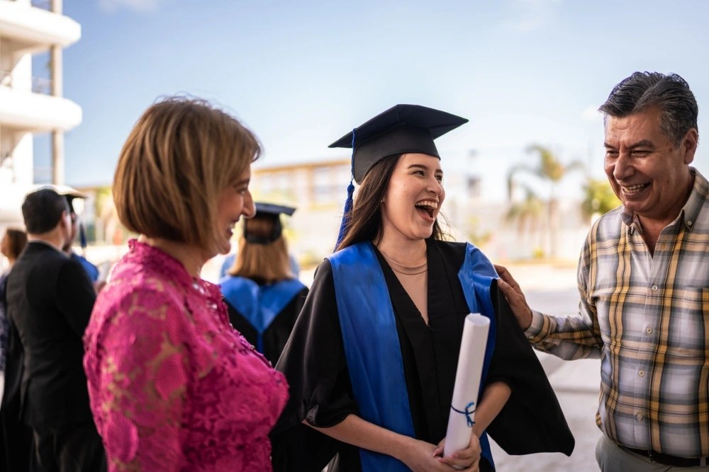 Padres con hija recién graduada.