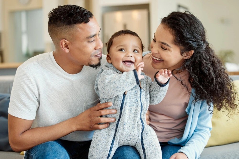 Familia con su bebé: Familia planifica cómo ahorrar dinero para sus hijos.