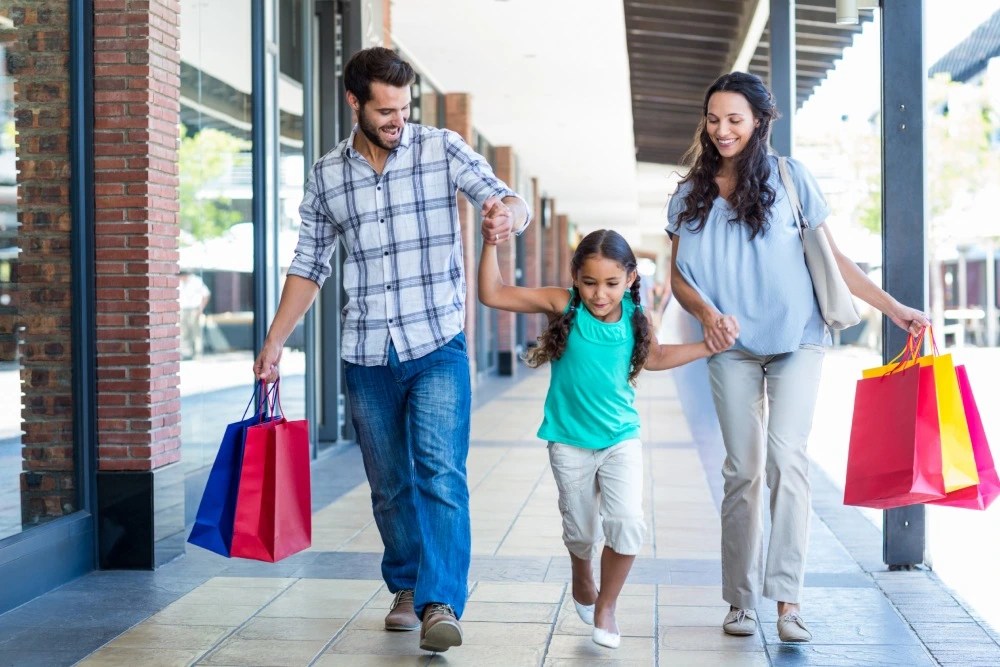 Padres e hija haciendo compras en cyber monday gracias a consejos financieros.