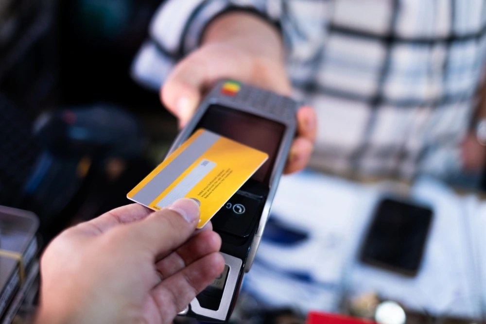 Persona pagando con su tarjeta bancaria.