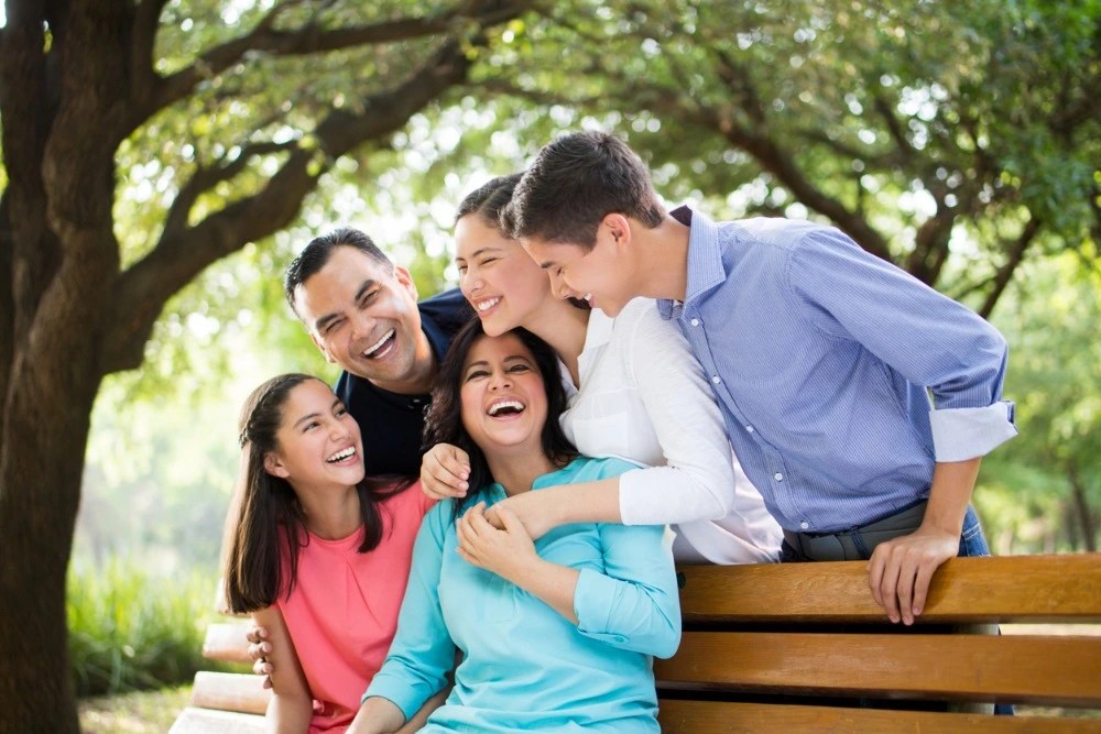 Familia de 5 feliz tras invertir para futuro de hijos.