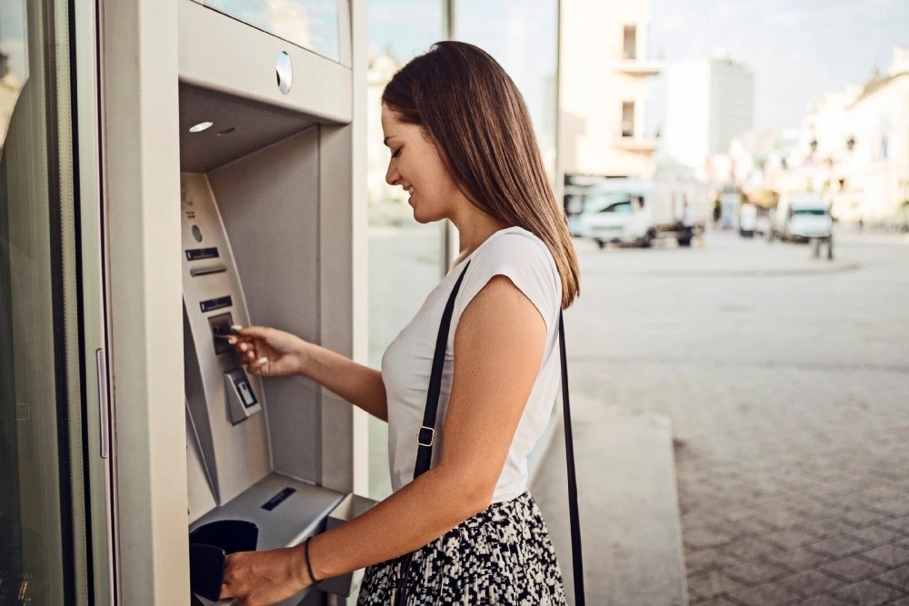 Mujer haciendo retiro de efectivo en cajero automático.