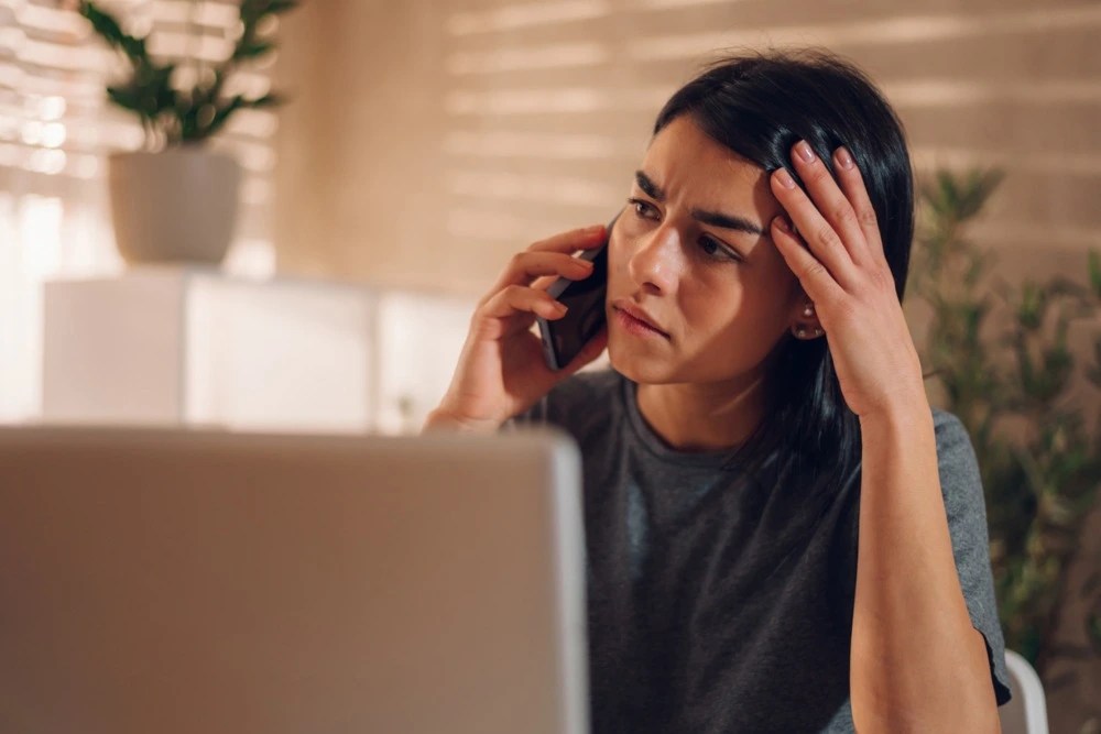 Mujer hablando por teléfono reportando un fraude en línea