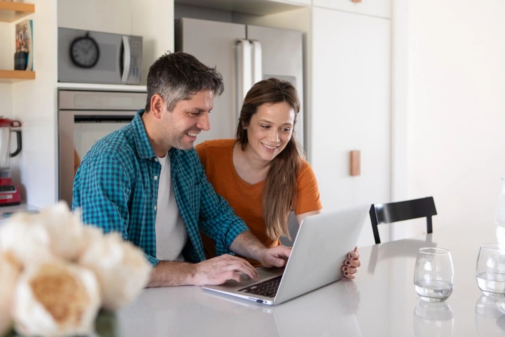 Pareja navegando en su computadora.