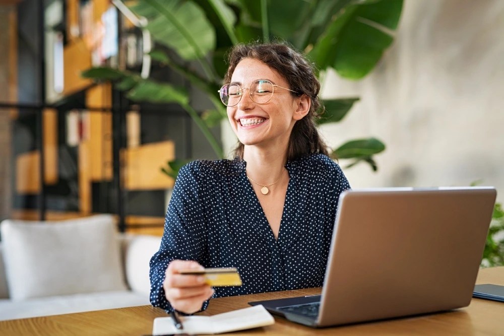 Mujer pagando compras online con tarjeta de débito.