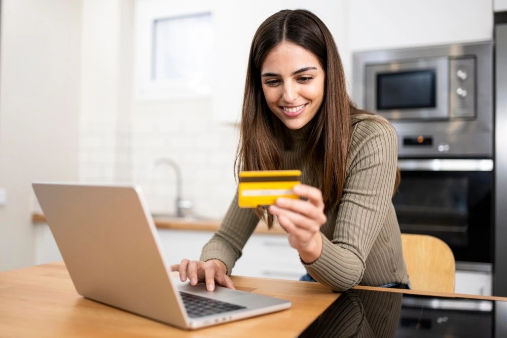 Mujer utilizando su tarjeta de crédito en compras en línea.