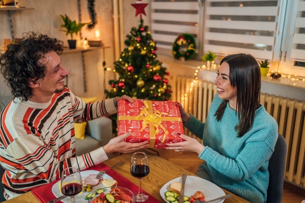 Pareja intercambiando regalos navideños.