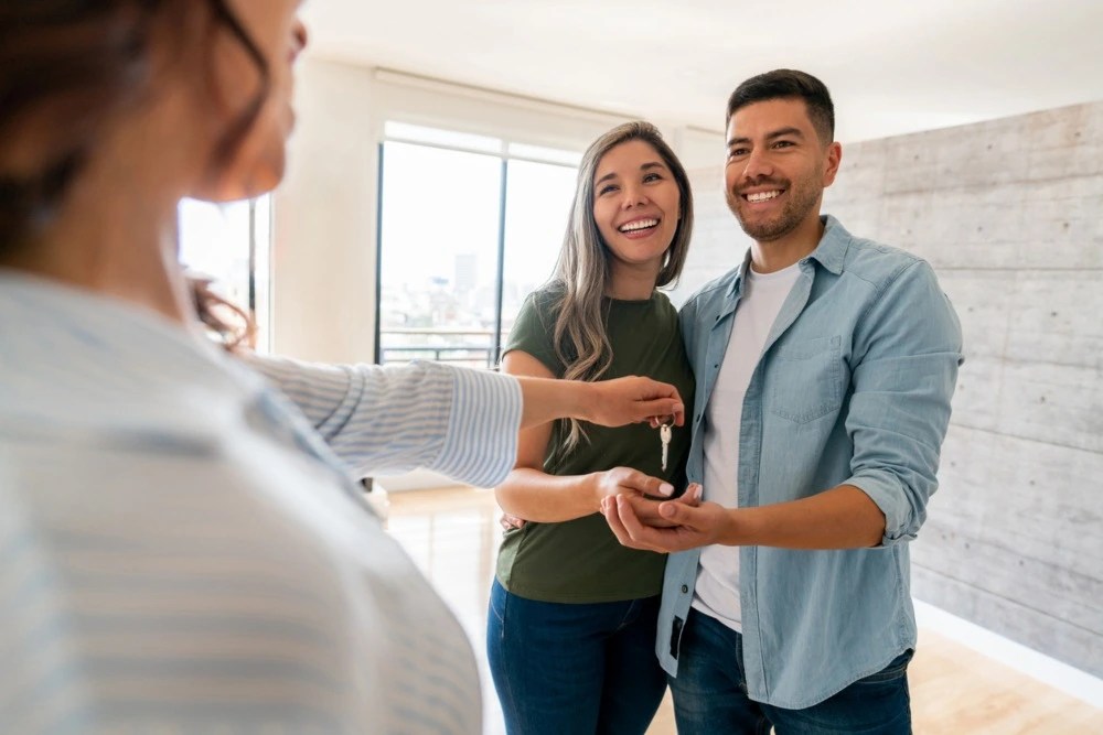 subcuenta de vivienda: Pareja recibiendo llaves de su casa.