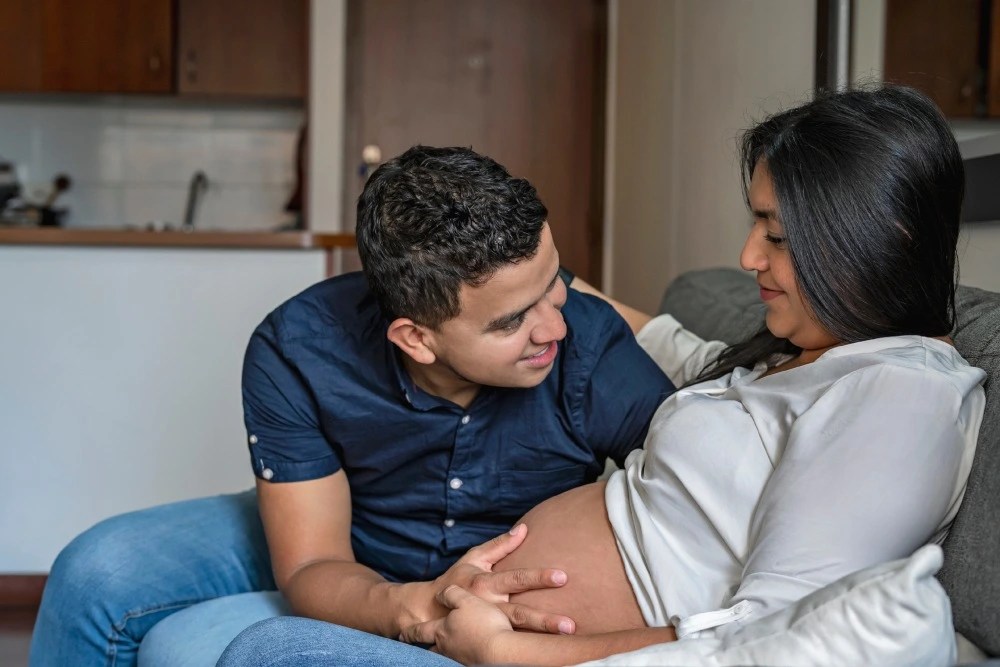 Mujer embarazada y esposo con seguro de salud familiar.