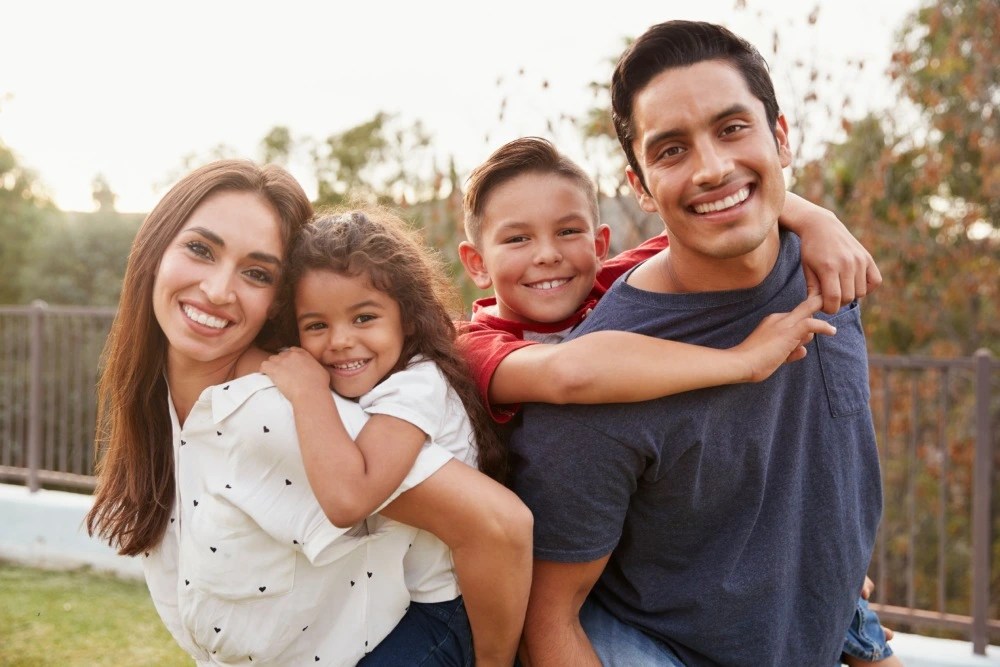 Padres con sus dos hijos con seguro de vida.