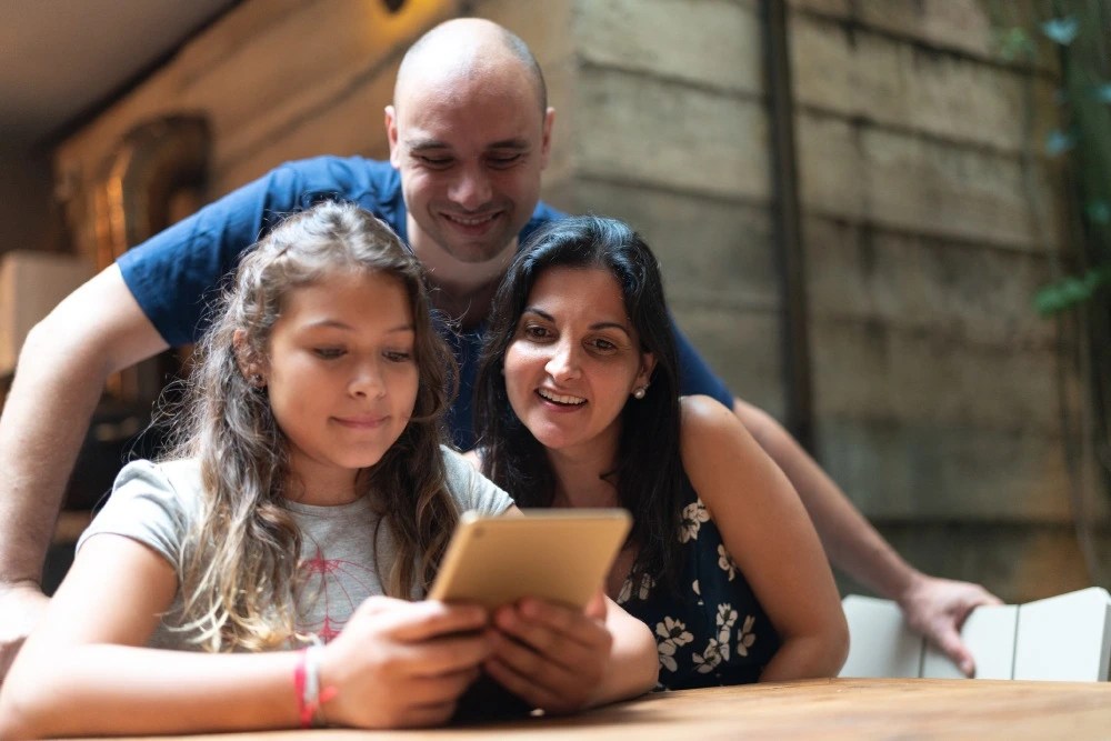 Padres e hija aprendiendo sobre finanzas para niños