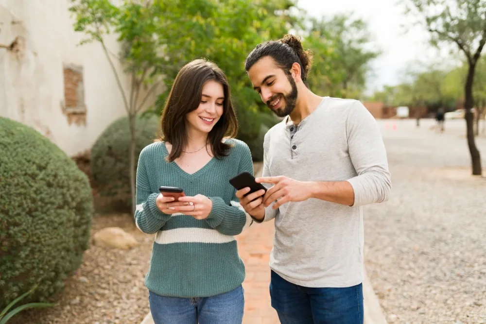 Hombre y mujer revisando sus celulares haciendo pago codi