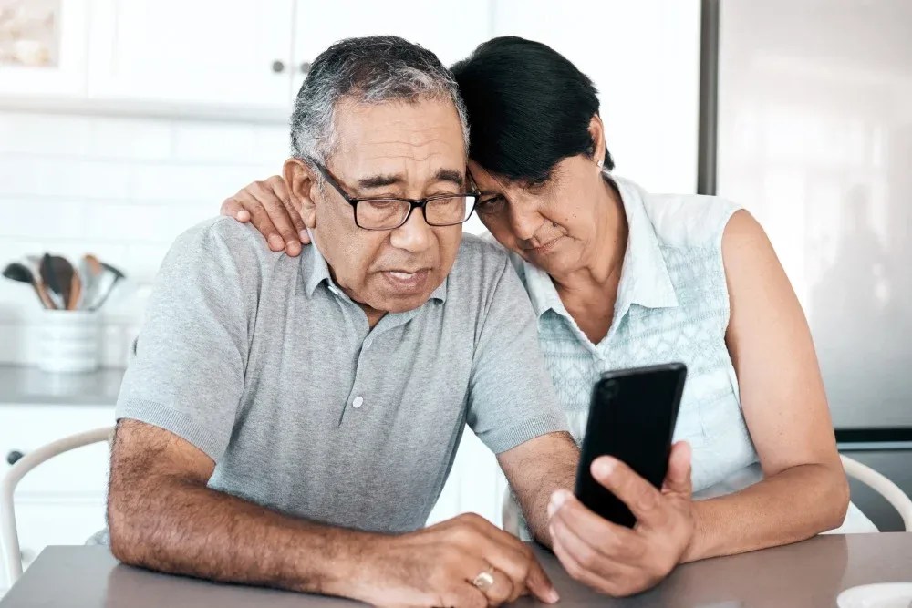 Pareja de adultos mayores revisando su celular