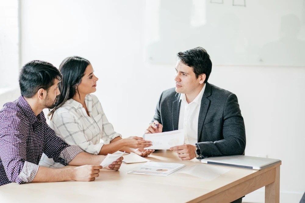 Pareja presentando los requisitos para un préstamo personal.