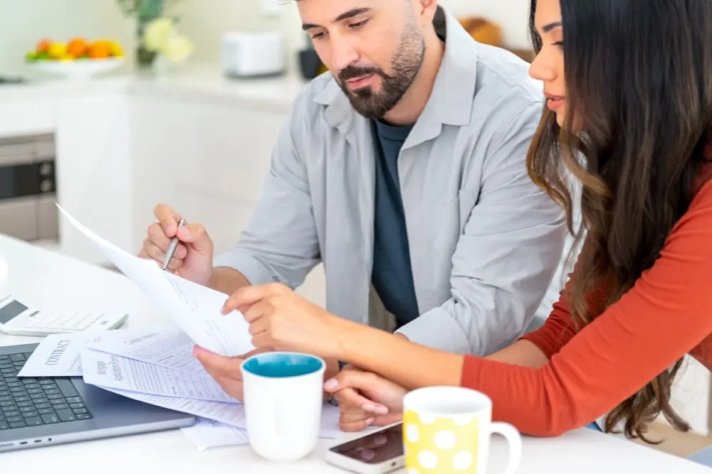 Pareja revisando cómo pueden recortar sus gastos