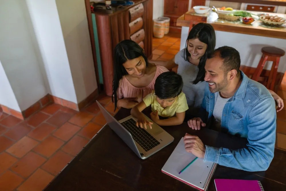 Padre con sus 3 hijos aprendiendo sobre finanzas y ahorro