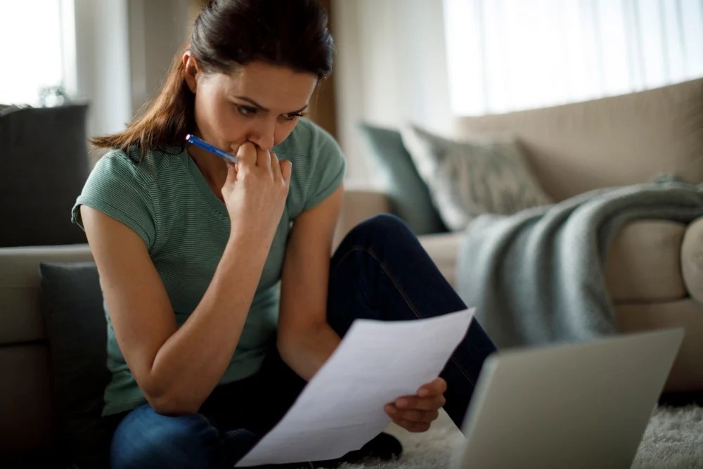 Mujer revisando sus cuentas y analizando cómo reducir sus deudas