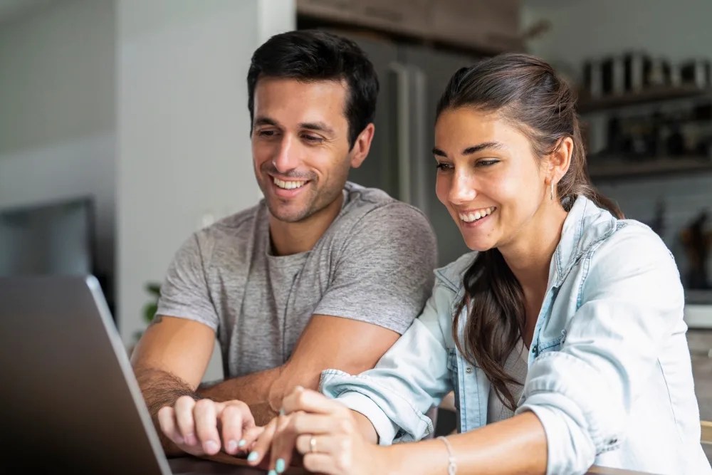 pareja en computadora saldando sus deudas