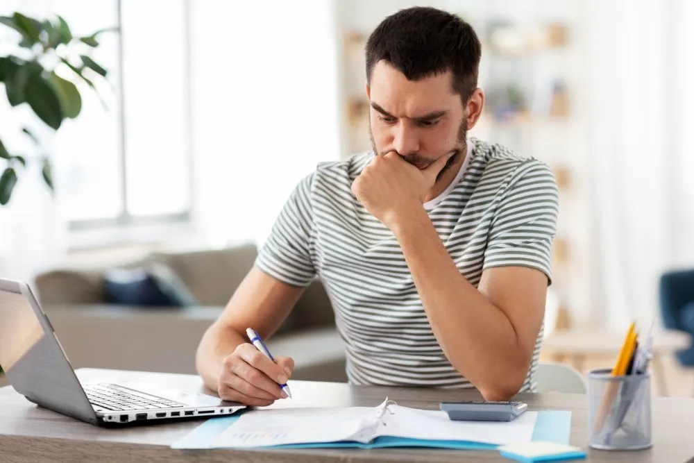 Hombre calculando cómo salir de sus deudas