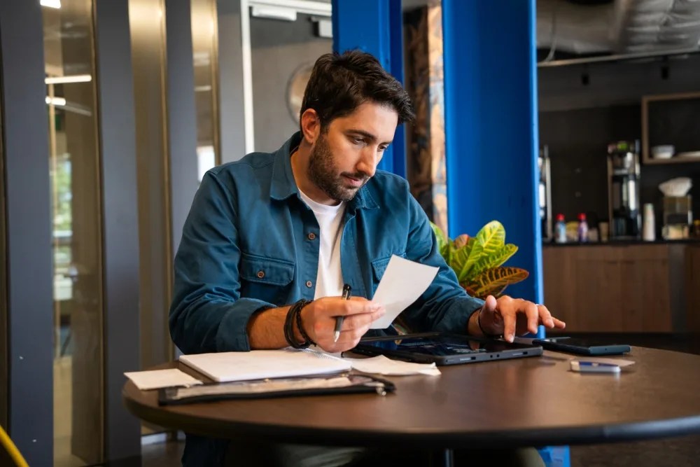 hombre con papeles y sacando cuentas