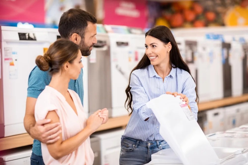 pareja con vendedora revisando oferta en productos del hogar