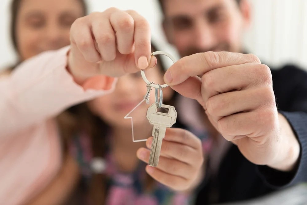 Familia con las llaves de su nuevo hogar tras comprar con infonavit