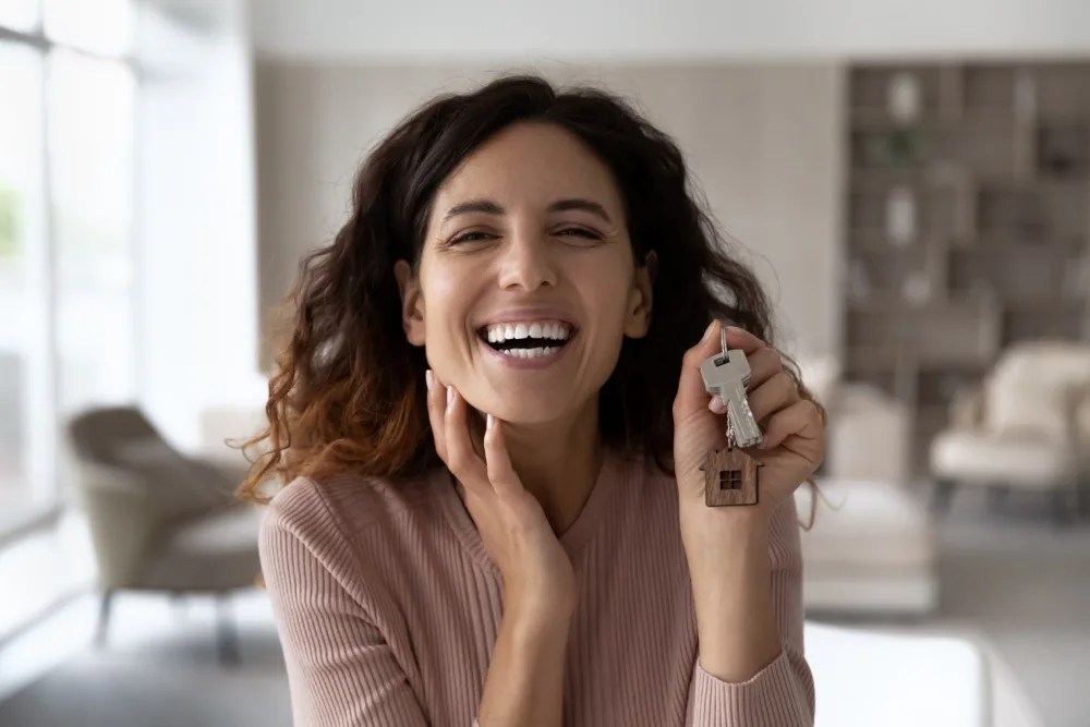 Mujer con las llaves de su nueva casa adquirida con crédito hipotecario