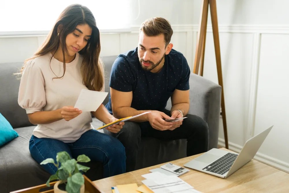 Mujer y hombre revisando boletas para pagar sus deudas