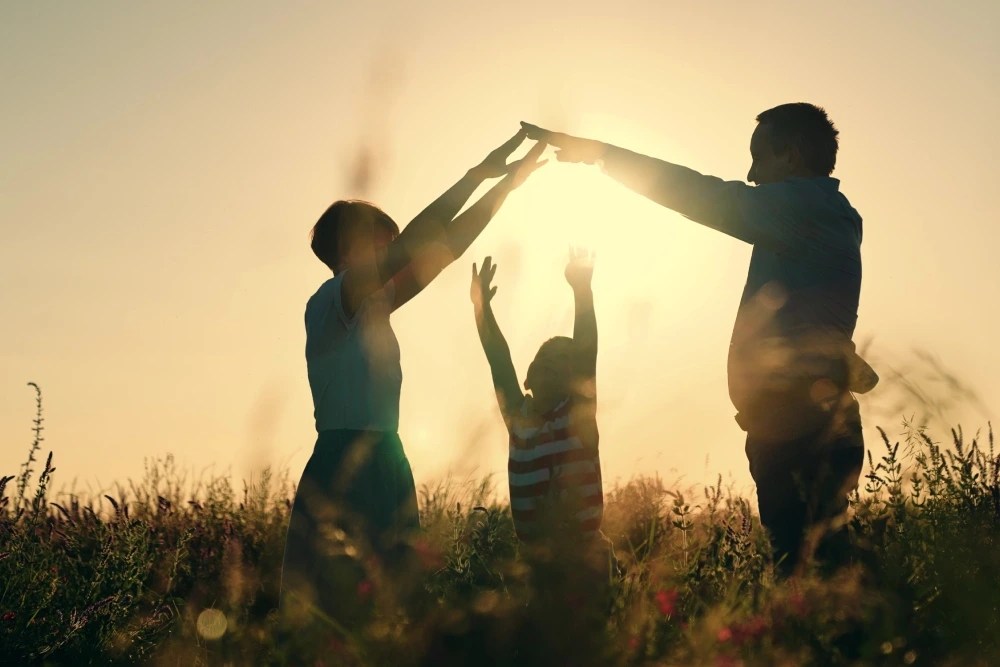 seguridad económica: padres formando casa con los brazos sobre hijo