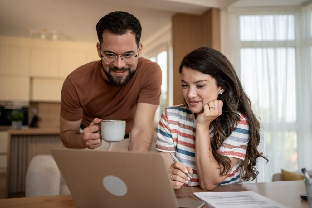 Pareja revisando en computadora cómo rehipotecar su casa
