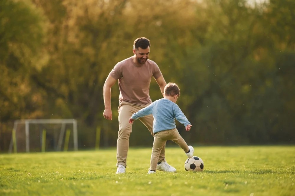 economía familiar: padre jugando al fútbol con hijo