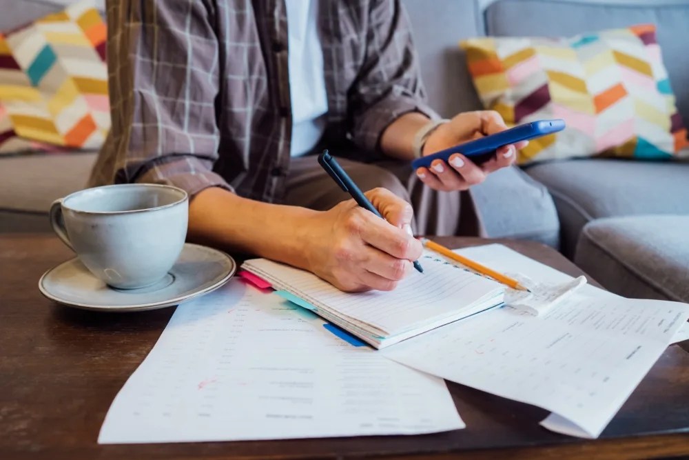 cómo distribuir mis ingresos: persona anotando sus gastos